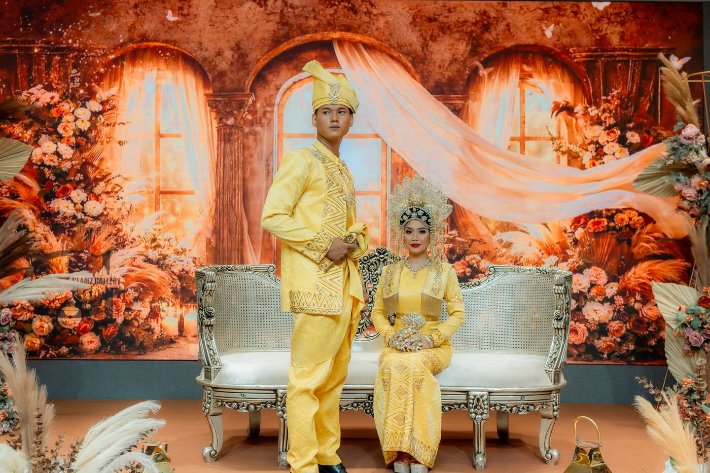 Couple seated on a decorated nikah stage