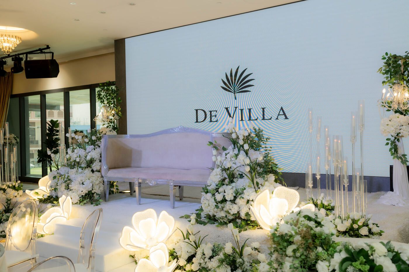 De Villa wedding stage with white florals and aisle styling