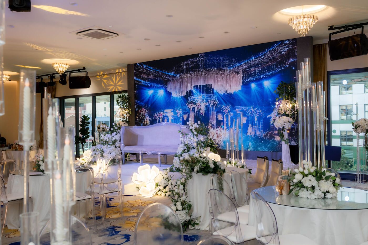Warm-lit wedding stage with floral arrangements